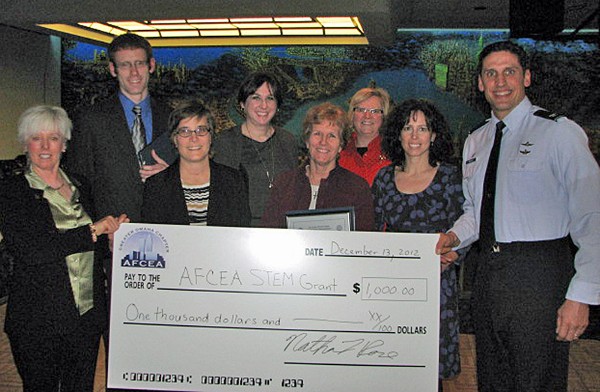 Chapter leaders and grant recipients gathering in December are (l-r) Nancy Crews, chapter vice president for academics; James McDermott, Holy Name Elementary School; Tara Petersen, Mary Our Queen Catholic School; Linda Sweeting, St. Marys School; Mary Jo Holdcroft, St. Matthews Catholic School; Janis Elliot, Bellevue West High School; Tamara Vering, Guardian Angels High School; and Col. Donovan L. Routsis, USAF, chapter president.